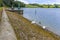 A view along the eastern bank and slope leading into Raventhorpe Water, Northamptonshire, UK