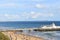 View along a packed beach and pier with ocean