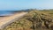 View along sand dunes towards the ruins of Dunstanburgh Castle.