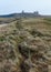 View along sand dunes towards the ruins of Dunstanburgh Castle.