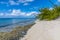 A view along a sandy the beach with rocky shore on the island of Eleuthera, Bahamas