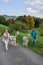 View of alpacas walking with Caucasian women in greenery field