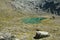 View of alpine lake with emerald water near the alm of Giogo Lungo