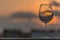 View of a amazing empty glass of wine standing tall, sunset as background