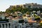 View of the ancient Acropolis, Erechtheion, from Monasteraki Square through old town buildings and Hadrian`s Library ruins