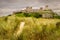 A view of an ancient castle on top of a grass hill