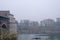 View of the Ancient Covered Bridge and the city surrounded by fog in winter. Pavia. Italy