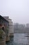 View of the Ancient Covered Bridge and the city surrounded by fog in winter. Pavia. Italy