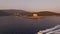 View of the ancient fortress Arza on the Lustica peninsula, Mamula island and motor boat sailing near them at sunset