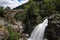 View of the ancient Mizarela Bridge or Devilâ€™s Bridge with a waterfall, at the Peneda Geres National Park