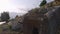 View of ancient tombs carved in mountain cliff near the asphalt road.