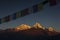 View of Annapurna South at sunset from Poon Hill with buddhist flags. Himalaya Mountains, Nepal