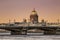 View of the Annunciation bridge across the Neva river and the dome of St. Isaac`s Cathedral at sunset. Saint Petersburg