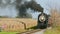 View of an Approaching Antique Steam Passenger Train, Blowing Black Smoke, Passing Corn Fields