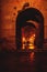 View through arch in medieval fort walls `Torres de Quart` to illuminated street during night in Valencia, Spain