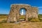 A view through an arch in the ruins of Edmunds priory toward the old lighthouse at Hunstanton, Norfolk, UK