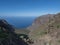 View of arid subtropical landscape of Barranco de Guigui Grande ravine with cacti and palm trees viewed from hiking