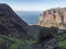 View of arid subtropical landscape of Barranco de Guigui Grande ravine with cacti and palm trees viewed from hiking