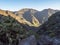 View of arid subtropical landscape of Barranco de Guigui Grande ravine with cacti and palm trees viewed from hiking