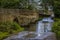 A view as a car crosses the ford of the bridge and ford over the River Ise in the town of Geddington, UK