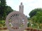 A view of the Ashoka Chakra / dharma wheel, walkway, and gardens surrounding the standing Buddha