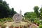 A view of the Ashoka Chakra / dharma wheel, walkway, and gardens surrounding the standing Buddha