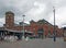 View of ashton open market with stalls shoppers and the historic market hall built in 1829