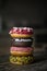 View of assortment colorful frosted delicious tasty stacked doughnuts. Colored sprinkle glazed donuts with marshmallow and