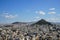 View of Athens city from Acropolis showing white buildings architecture, Mount Lycabettus, blue sky and floating white cloud