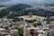 View of Athens cityscape from Acropolis showing ancient ruin landscape, buildings architecture, trees and white city background