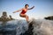 View on athletic woman who masterfully rides the wave on surfboard
