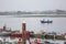 View of Aveiro river with fisherman boat with people sailing. Day with clouds and background with typical vegetation and buildings