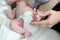 View at baby foot in mother hand, infant lying on bed during breast-feeding