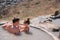 view from back. a father and daughter bathe in a hydrogen sulfide thermal spring