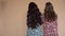 View from back of girls in light dresses with long hair