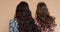 View from back of girls in light dresses with long hair