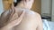 View from back slim men hand applying cream on woman shoulder and back. male help female apply body lotion.