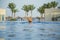 View from back of white european tourist swimming in blue water