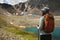 view from the back, a woman tourist stands with a backpack and sticks in panama under the sun, looks at the lake and