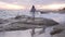 View from the back, woman walking on rocky beautiful beach at sunset in autumn