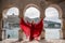 View of Balaklava Bay through an arched balcony in oriental style. The girl in a long red dress stands with her back