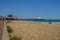 View of the band stand and the pier in Eastbourne on a bright blue sky summers afternoon. Two empty deckchairs sit on the shingle