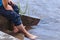 View of bare male feet in the water. A man cools his feet on the steps of the descent of the embankment of the river