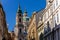 View of Baroque Church of Saint Nicholas, green dome and bell tower with clock, sunny winter day, snow on red roofs, Mala Strana