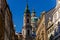 View of Baroque Church of Saint Nicholas, green dome and bell tower with clock, sunny winter day, snow on red roofs, Mala Strana