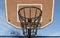 View of Basketball backboard with the hoop metal ring and steel chain net against blue sky background