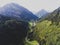 View of bavarian alpine village with a valley and mountains, shot from drone, Bayern, Bavaria, Germany, sunny summer day