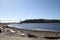 A view of a bay from a beach with driftwood sand and rock