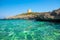 View on the beach Calo Roig with crystal water and the Defense Tower Alcaufar on Menorca