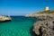 View on the beach Calo Roig and the Defense Tower Alcaufar on Menorca